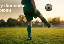 Футболист жонглирует мячом на поле