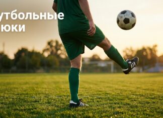 Футболист жонглирует мячом на поле