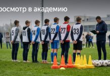 Юные футболисты на просмотре, тренер с планшетом